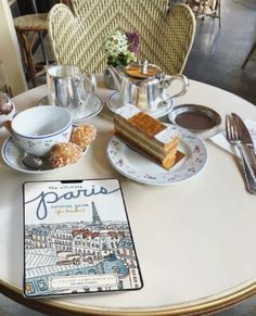 a table topped with plates and cups filled with food