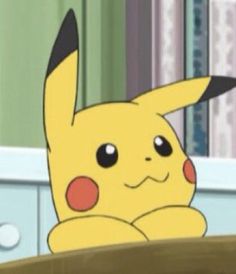 a pikachu sitting on top of a wooden table