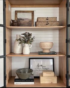 some shelves with vases and pictures on them