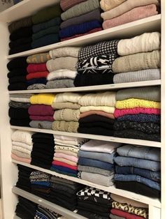 a closet filled with lots of folded clothes