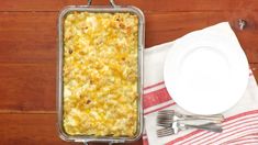 a casserole dish is sitting on a table next to a plate and fork