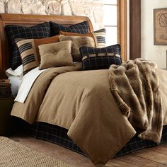 a bed covered in brown and black comforters