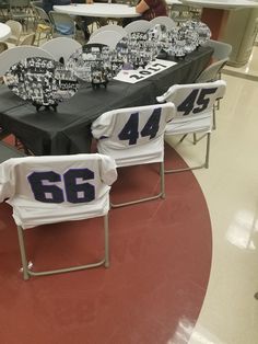 the tables are set up with black and white tablecloths for sports themed party