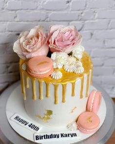 a birthday cake decorated with flowers and macaroons