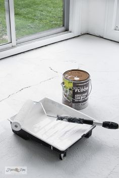 a can of paint sitting on top of a white tray next to a black spatula