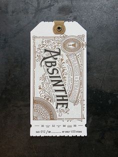 a tag with the word absanelle on it hanging from a hook in front of a black wall