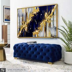 a blue bench sitting in front of a painting on the wall next to a potted plant