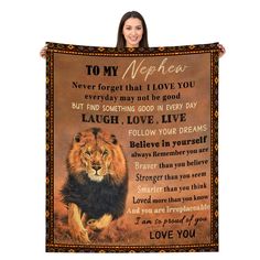 a woman holding up a blanket with an image of a lion and poem on it