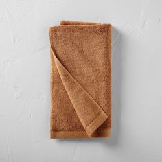 a brown towel is hanging on the wall next to it's folded end,