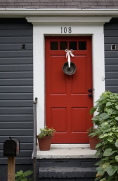 a red front door with a wreath on it