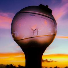 a clock on top of a pole with the sky in the background