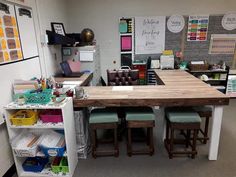 an office with several desks, chairs and shelves filled with crafting supplies on the wall