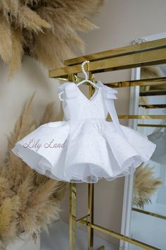 We have a magnificent offer for little princesses: an enchanting children's white, fluffy, short sleeveless dress is available for sale. This dress will be a real gem for special occasions as it is adorned with elegant lace and adorned with delicate tulle bows on the shoulders. Furthermore, the dress comes with a beautiful bead belt that accentuates the waist of the little fashionista and adds even more charm to her look. The white color of the dress makes it versatile, and it is perfect for any celebration. Whether it's a children's party, a wedding, a prom night, or even just a family gathering, this outfit will become a true trendsetter. Every little girl will feel like a real princess in this voluminous dress. It will create a unique image and attract admiring glances from those around Voluminous Dress, Bead Belt, White Baby Dress, Dress Photoshoot, Baby Party Dress, First Birthday Dresses, Puffy Skirt, White Lace Shorts