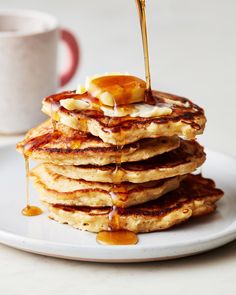 stack of pancakes with syrup being drizzled on top