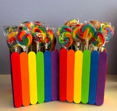 there are many lollipops in the holder on the table and one is rainbow