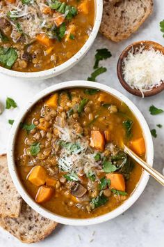 two bowls of soup with bread and parmesan cheese