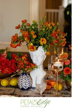 a vase filled with lots of flowers sitting on top of a table next to candles