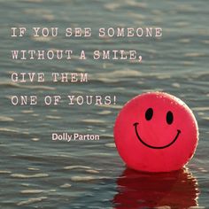 a red ball floating on top of water with a quote above it that says if you see someone without a smile, give them one of yours