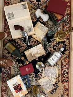 an area rug covered in books, wine bottles and other items sitting on top of it