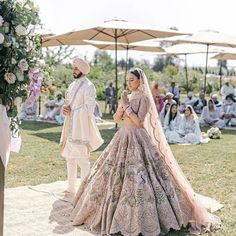 the bride and groom are standing in front of an outdoor ceremony area with umbrellas