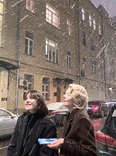 two women walking down the street in the snow