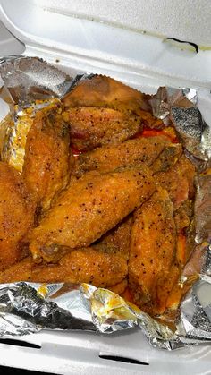 chicken wings in tin foil with seasoning on them