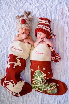 two babies laying next to each other in christmas stockings