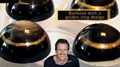 a man sitting in front of three black cakes on top of a white stovetop