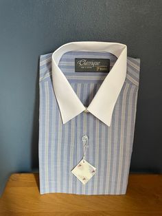 "Deadstock vintage blue shirt with narrow white and orange striped pattern and solid white straight collar from the Classique range by renowned shirt maker, Tootal, long sleeves, single cuff, regular fit in polyester cotton mix.  Size 15\" 38cm S/M" Classic Blue Shirt With Striped Collar, Blue Long Sleeve Dress Shirt With Striped Collar, Classic Long Sleeve Shirt With Vertical Stripes, Blue Dress Shirt With Striped Collar For Work, Business Pinstripe Dress Shirt With Spread Collar, Pinstripe Dress Shirt With Spread Collar For Business, Classic Long Sleeve Dress Shirt With Vertical Stripes, Fitted Pinstripe Dress Shirt With Striped Collar, Fitted Vertical Stripes Business Shirt