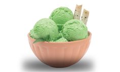 three scoops of green ice cream in a pink bowl with crackers sticking out of it