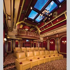 an empty theater with leather seats and chandeliers on the ceiling is pictured in this image