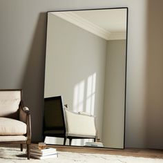 a mirror sitting on top of a wooden floor next to a chair