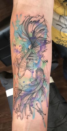 a watercolor tattoo on the arm of a person with a bird in it's beak