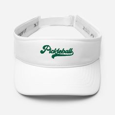 The Pickleball Visor is perfect gift ideas for pickleball players, providing both style and functionality on the court. These accessories serve as thoughtful gifts for pickleball enthusiasts, especially women, offering sun protection and a sporty look during gameplay. * 97% polyester, 3% spandex * Low-profile * 2 ½″ (5 cm) crown * Matching undervisor * Hook & loop closure with square ring * Head circumference: 22″-23 ⅜″ (56 cm-59 cm) Adjustable White Hat For Tennis, White Adjustable Hat For Tennis, Adjustable White Tennis Hat, White Adjustable Tennis Hat, Adjustable White Visor For Outdoor Activities, White Sports Fan Baseball Cap, Sporty Adjustable Tennis Hats, White Sports Visor, White Sporty Visor For Sports