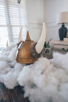 a helmet sitting on top of a pile of white fluffy clouds next to a lamp