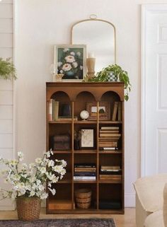 a living room with a book shelf and flowers