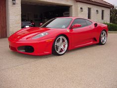 a red sports car parked in front of a garage