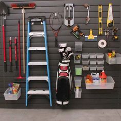 a garage with various tools hanging on the wall and in front of it is a ladder