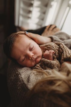 a baby sleeping on top of a blanket next to a window