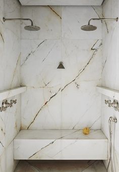 a bathroom with marble walls and flooring in the shower area is featured on instagram