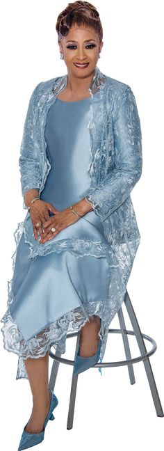 a woman sitting on top of a chair wearing a blue dress and matching jacket with heels