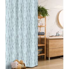 a bathroom with a blue shower curtain next to a wooden dresser and toilet in front of a mirror