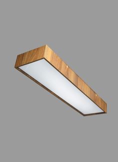 a wooden light fixture with white glass on the bottom and wood trim around the edge