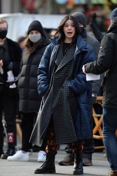 a woman wearing a face mask while walking down the street with other people behind her