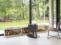 a chair and firewood in front of a window