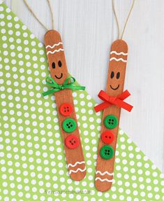 two wooden pegs decorated with buttons and smiling faces on green polka dot paper background