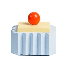 an orange sitting on top of a block of cheese