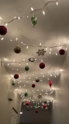 christmas lights are hanging from the ceiling in an empty room with white walls and ceilings