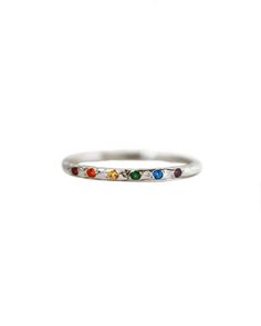 Let your inner rainbow shine and guide you through all of life's ups and downs. This gorgeous hand textured ring features a sparkling rainbow of gemstones. Delicate and comfortable to wear, this sterling silver rainbow ring is perfect for stacking with your favorite rings or even as a solo statement ring. A percentage of the proceeds from this ring go directly to organizations that support the LGBTQIA+ community globally Details:- A rainbow of sparkling genuine sapphire and topaz gemstones (exac Rainbow Sterling Silver Promise Ring, Rainbow Sterling Silver Rings As Gift, Rainbow Multi-stone Stackable Promise Rings, Rainbow Multi-stone Stackable Rings For Promise, Multicolor Sterling Silver Stackable Rings, Adjustable Rainbow Gemstone Ring, Rainbow Stackable Jewelry For Promise Ring, Sculpted Jewelry, Rainbow Band