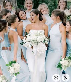 a group of women standing next to each other holding bouquets and smiling at the camera